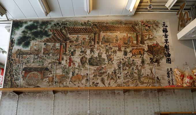 牆上的圖畫介紹元福的古法麻油製程，元福麻油堅持傳統榨油法，保留芝麻豐富的營養價值。